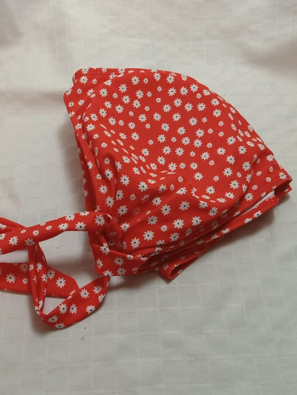 Red, white, and black floral swimsuit top with a bow at the front; never worn